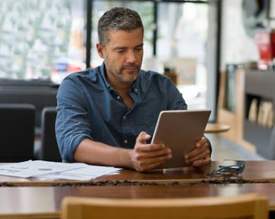 Man sitting at table reading tablet